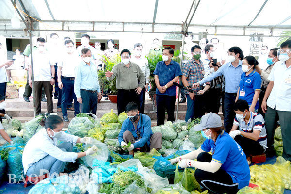 Thủ tướng Phạm Minh Chính thăm hỏi các tình nguyện viên Tổ an sinh xã hội xã Thạnh Phú (H.Vĩnh Cửu) đang đóng gói thực phẩm để chuyển đến hỗ trợ công nhân các khu nhà trọ. Ảnh: C.Nghĩa