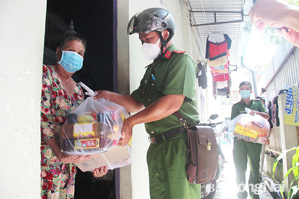 Công an P.Long Bình (TP.Biên Hòa) trao gói quà cho một hộ dân khó khăn tại KP.7, P.Long Bình. Ảnh: Trần Danh