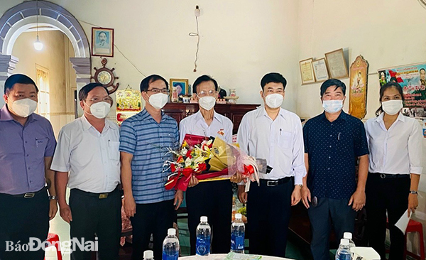 Lãnh đạo Huyện ủy tặng hoa chúc mừng và chụp hình lưu niệm với đồng chí Nguyễn Đình Bá