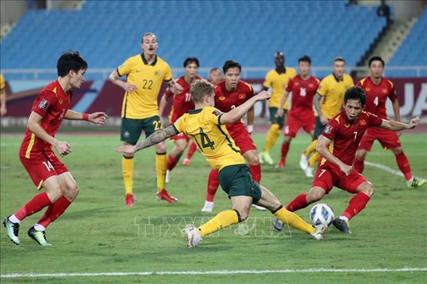 Footballers of Vietnam (in red) and Australia vie for the ball (Photo: VNA)