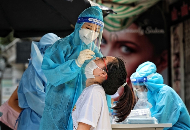 A medical worker takes a sample from a resident in Hà Nội's Hai Bà Trưng District for COVID-19 testing. — VNA/VNS Photo 