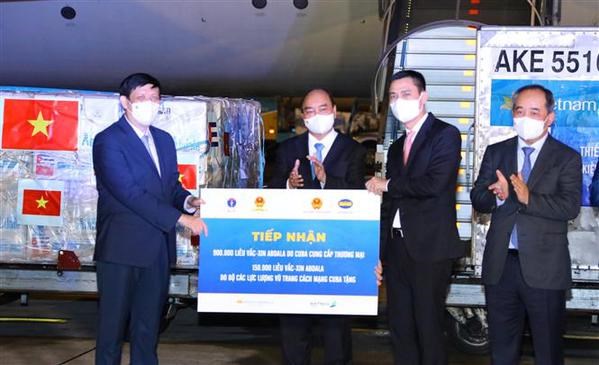 President Nguyen Xuan Phuc attends (second, left) witnesses the symbolic reception of 1.05 million Abdala vaccine at Noi Bai airport in Hanoi on September 25 evening. 