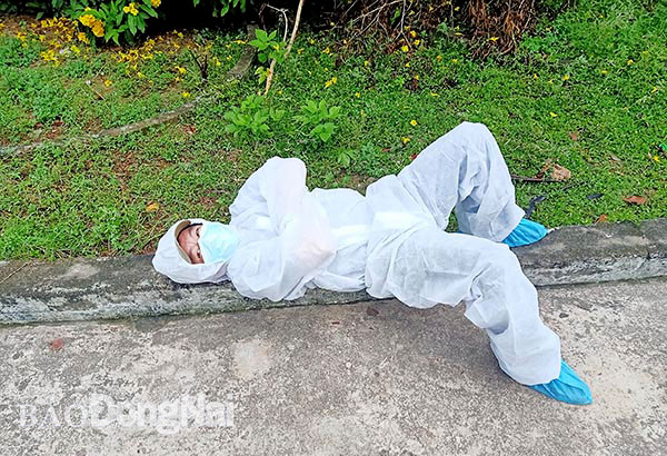 Anh Lê Công Trung, tài xế Trung tâm Y tế H.Tân Phú, tranh thủ nằm nghỉ bên lề đường khi chờ đón các ca F1 hết cách ly