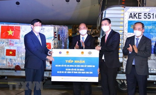 Vietnamese President Nguyen Xuan Phuc (second from left) witnesses the symbolic handover of 1 million doses of Cuba's COVID-19 vaccine from the foreign ministry to the health ministry at Noi Bai International Airport on September 25. 