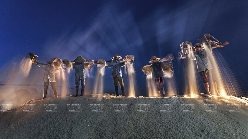 The work “Harvesting salt at night” by Do Tuan Ngoc.