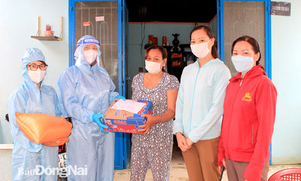 Chủ tịch Hội LHPN tỉnh Lê Thị Thái (thứ 2 từ trái sang) động viên, tặng quà hội viên phụ nữ hoàn cảnh khó khăn tại H.Định Quán. Ảnh: Nga Sơn