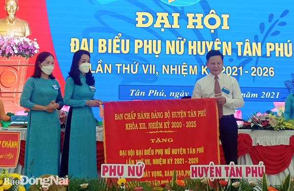 Phó bí thư thường trực Huyện ủy Tân Phú Huỳnh Phước Sang tặng bức trướng chúc mừng đại hội của Ban chấp hành Đảng bộ huyện Tân Phú (Ảnh: Hội LHPN tỉnh cung cấp)