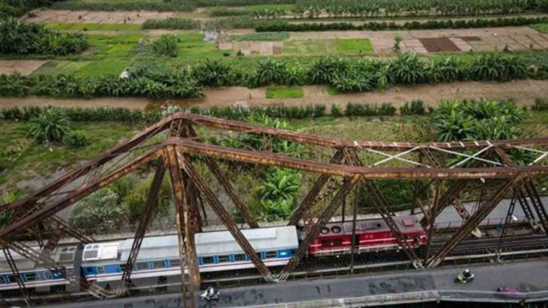 The LP6 passenger train passes through the Long Bien Station in Hanoi. Nine new railways are expected to be developed by 2030 - PHOTO: VNA