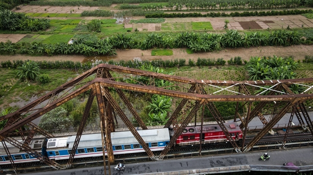 A train from northern Hải Phòng City crosses Long Biên Bridge in Hà Nội before entering Long Biên Railway Station on October 13. — VNA/VNS Photo 