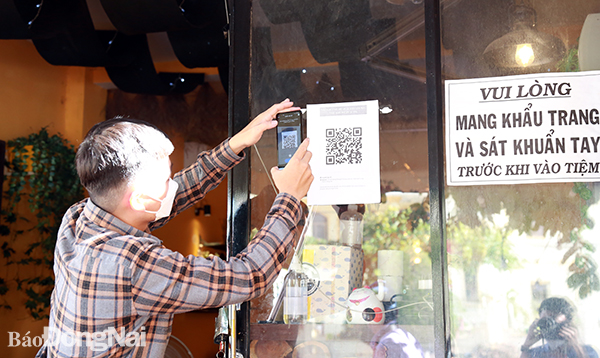 Một khách hàng quét mã QR-Code trước khi vào một quán cà phê tại P.Xuân An