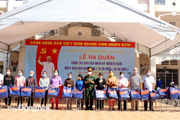 Đại tá Bùi Văn Sỹ, Phó chính ủy Bộ Chỉ huy quân sự tỉnh trao quà của Bộ Quốc phòng hỗ trợ người dân khó khăn do Covid-19 trong lễ ra quân làm dân vận của lực lượng vũ trang H.Định Quán. Ảnh: Nguyệt Hà