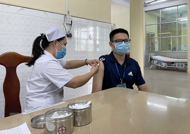 A medical worker gives a Covid vaccine shot to a man in Dong Nai Province – PHOTO: VNA