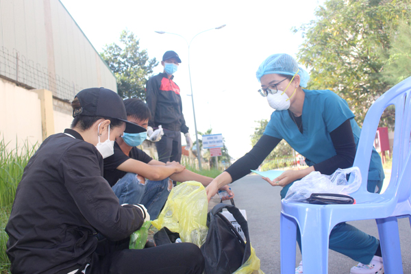 Điều dưỡng Trần Thị Kiều Linh (Bệnh viện Đa khoa Đồng Nai) trao trả từng món đồ là kỷ vật của một bệnh nhân đã tử vong do Covid-19 cho gia đình bệnh nhân