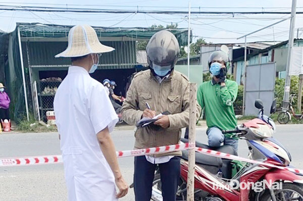 Bệnh nhân đến chốt kiểm soát phòng dịch ở khu vực giáp ranh giữa TP.Biên Hòa và H.Vĩnh Cửu để ký nhận thuốc ARV về điều trị tại nhà thời điểm thực hiện giãn cách xã hội. Ảnh: Phương Liễu