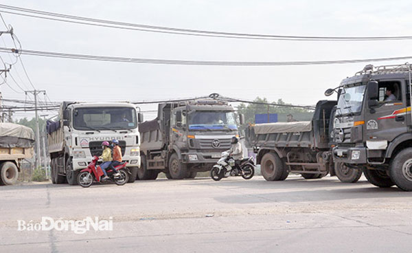 Xe máy len lỏi giữa xe tải, ben hướng từ đường chuyên dùng ra quốc lộ 51. Ảnh: Thanh Hải