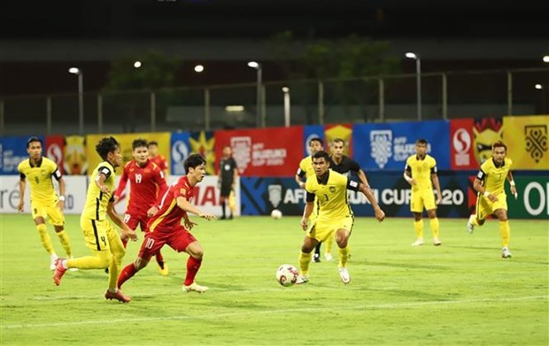 Nguyen Cong Phuong (No.10 in red) fooled three defenders with his close control and dribbling before unleashing a superb finish past Malaysian goalie (Photo: VNA)