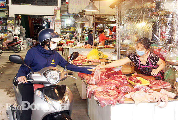 Người dân chọn mua các sản phẩm thịt heo tại chợ Tân Hiệp (TP.Biên Hòa). Ảnh: H.Quân