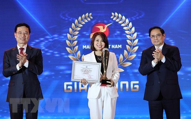 Prime Minister Pham Minh Chinh (right) and Minister of Information and Communications Nguyen Manh Hung (left) present the gold prize to a winner.