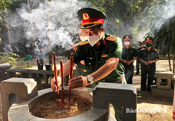 Đại tá Vũ Văn Điền thắp hương viếng liệt sĩ tại Căn cứ Trung ương Cục miền Nam. Ảnh: Nguyệt Hà