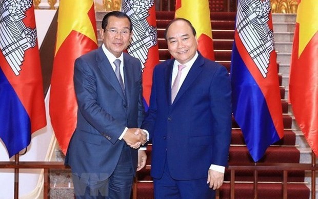 Then Prime Minister Nguyen Xuan Phuc (R) welcomes his Cambodian counterpart Samdech Techo Hun Sen during the latter's visit to Vietnam in October 2019.