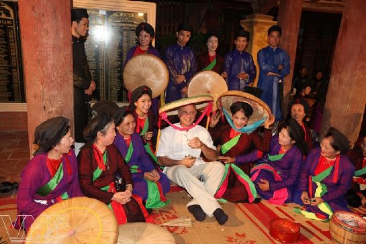 A foreign tourist enjoys his time with Quan Ho singers. (Photo: Internet)