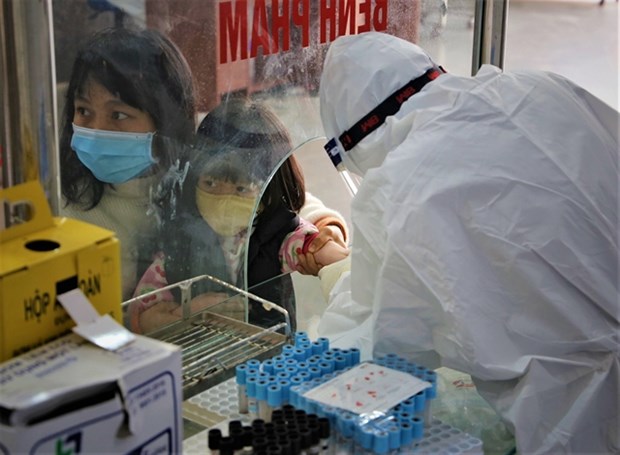 A health worker collects specimens from a young child infected with coronavirus in the northern province of Bac Giang. (Photo: VNA)