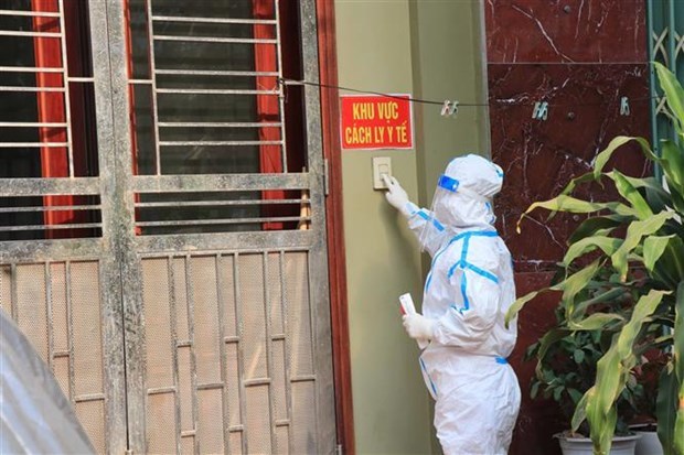 A medical staff at the door of a house with COVID-19 infected residents in the northern province of Bac Ninh to give medicine and collect samples for testing. (Photo: VNA)