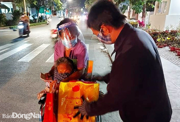  Các thành viên Câu lạc bộ Hoa Bác Ái (TP.Biên Hòa) trao quà tết cho người lang thang cơ nhỡ, gia đình khó khăn tối 29-1 (nhằm 27 tháng Chạp). (ảnh: Nguyễn Duyên)