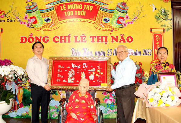 Chủ tịch UBND TP.Biên Hòa Nguyễn Hữu Nguyên (trái) tặng quà chúc thọ cụ bà Lê Thị Não