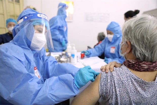 An elderly woman in Hang Bong ward of Hanoi's Hoan Kiem district receives a vaccine shot in early February 2022. (Photo: VNA)