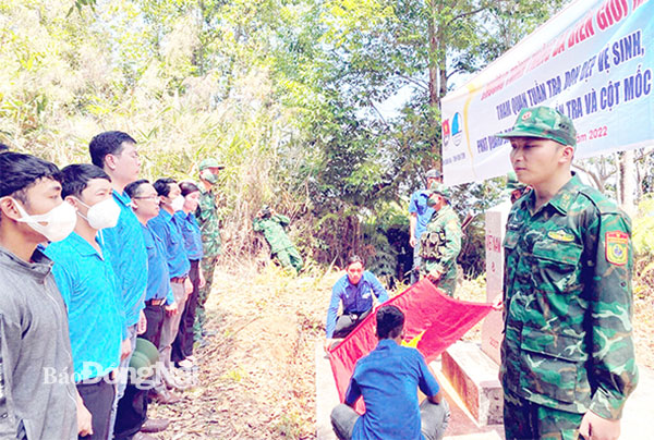 Cán bộ, đoàn viên và các chiến sĩ cùng thực hiện nghi thức chào cờ tại cột mốc biên giới số 8. Ảnh: Tỉnh đoàn cung cấp