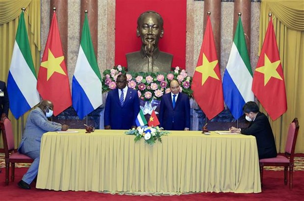President Nguyen Xuan Phuc (right) and Sierra Leonean President Julius Maada Bio witness the signing of a  cooperation agreement between the two countries in agriculture. 