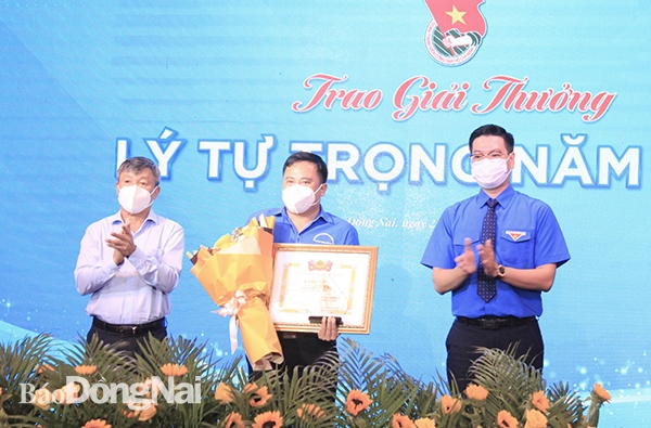 Đồng chí Hồ Thanh Sơn (bìa trái), Phó bí thư thường trực Tỉnh ủy và Phó bí thư thường trực Tỉnh đoàn Võ Văn Trung (bìa phải) trao bằng khen, biểu trưng và hoa cho một đại biểu duy nhất của Đồng Nai đoạt giải thưởng Lý Tự Trọng của Trung ương Đoàn