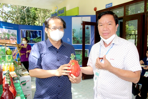 Ông Ngô Thanh Long (trái), Cơ sở sản xuất rượu vang thanh long Anna giới thiệu sản phẩm bên lề một hội nghị