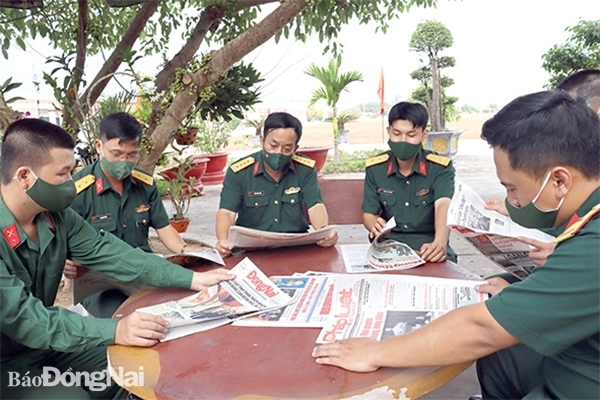 Đại tá Trần Hoài Nam (giữa), Bí thư Đảng ủy, Chính ủy Lữ đoàn 96 và cán bộ các cấp đọc báo cùng chiến sĩ mới trong giờ giải lao. Ảnh: N.Hà