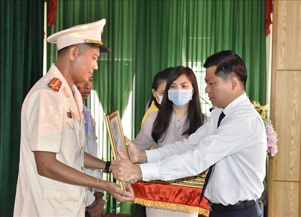 Captain Thai Ngo Hieu (L) receives a certificate of merit for his brave act. (Photo: VNA)