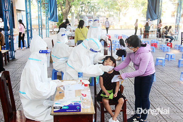 Nhân viên y tế lấy mẫu xét nghiệm Covid-19 cho học sinh TP.Biên Hòa. Ảnh minh họa: Trần Danh