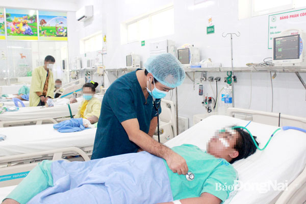 Bác sĩ kiểm tra sức khỏe cho một bệnh nhân bị sốc sốt xuất huyết nặng phải truyền dịch cao phân tử tại Bệnh viện Nhi đồng Đồng Nai. Ảnh: Hạnh Dung