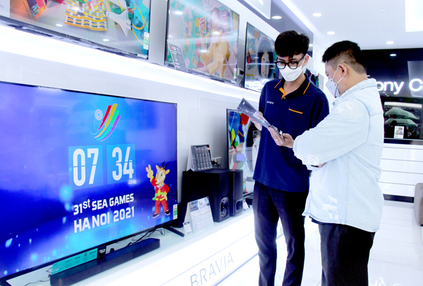 Khách hàng tham khảo các kênh xem trực tuyến khi chọn mua tivi ở một trung tâm điện tử trên đường Phạm Văn Thuận (TP.Biên Hòa). Ảnh: H.Hà