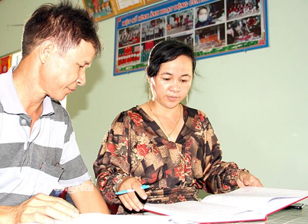 Trưởng ban Công tác Mặt trận ấp 1, xã Xuân Tây (H.Cẩm Mỹ) Lê Thị Nhàn cùng thành viên Ban ấp rà soát danh sách hộ khó khăn cần trợ giúp. Ảnh: Sông Thao