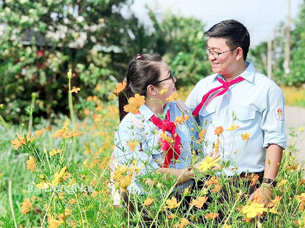 Cặp đôi Trần Minh Huân và chị Đinh Hoàng Nhi chụp hình lưu niệm trong trang phục áo phụ trách Đội TNTPHCM (TP.Biên Hòa). Ảnh: NVCC