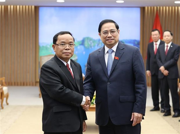 Prime Minister Pham Minh Chinh (R) receives President of the Lao State Inspection Authority Khamphan Phommaphat.