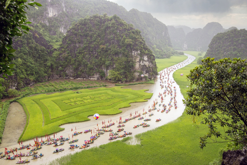 A parade takes place along a river in Ninh Binh Province, Vietnam. 