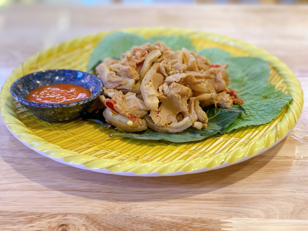 Sour pork is served with fresh herbs and a chili sauce