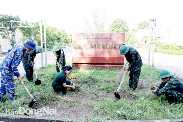 Các hộ gia đình quân nhân tham gia dọn vệ sinh môi trường tại khu nhà công vụ, góp phần xây dựng khu văn hóa quân nhân. Ảnh: N.Hà