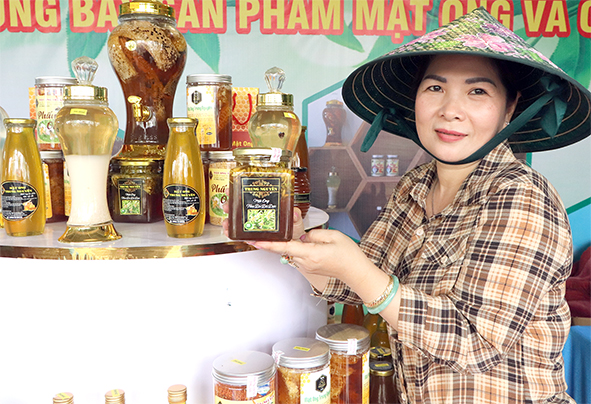 Chị Lê Thị Thanh Thúy, chủ Cơ sở Mật ong Trung Nguyên giới thiệu đặc sản mật ong ngâm hoa đu đủ. Ảnh: B.Nguyên