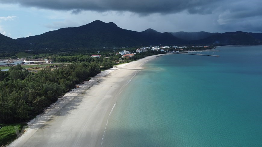 A beach next to an expanded strip of white sand. 