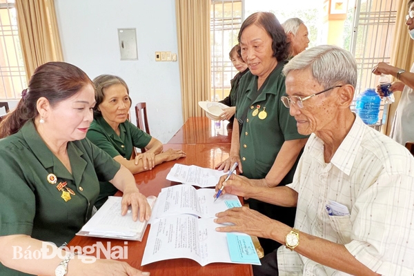 Thương binh Lâm Xuân Thảo hỗ trợ cựu chiến sĩ cách mạng bị địch bắt tù đày P.Xuân An (TP.Long Khánh) làm giấy tờ để trình giải quyết chính sách