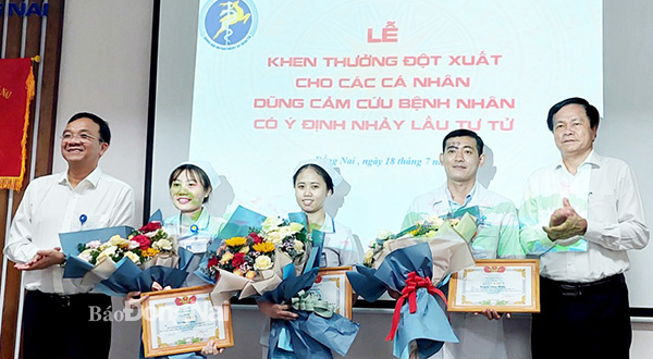 Phó giám đốc Sở Y tế Nguyễn Văn Bình và Giám đốc Bệnh viện Đa khoa Đồng Nai Ngô Đức Tuấn trao giấy khen, tặng hoa cho các cá nhân. Ảnh: Hạnh Dung