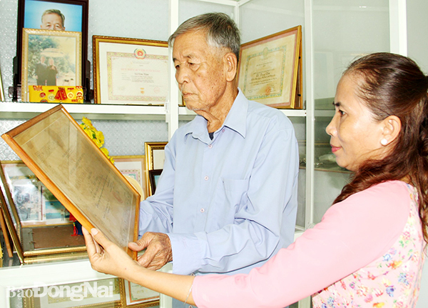 Thương binh Lê Văn Tâm giới thiệu về những phần thưởng mình vinh dự nhận được trong thời gian qua. Ảnh: S.Thao